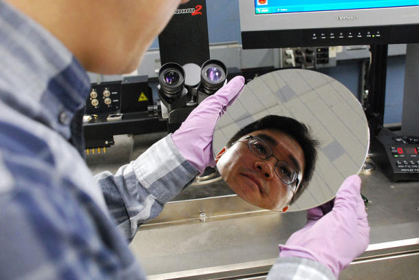 IBM研究者检查有碳纳米管的芯片晶片。晶圆的表面有两种物质，分别是二氧化硅和二氧化铪，二氧化铪形成的沟道能够吸引碳纳米管附着，而二氧化硅则不能。