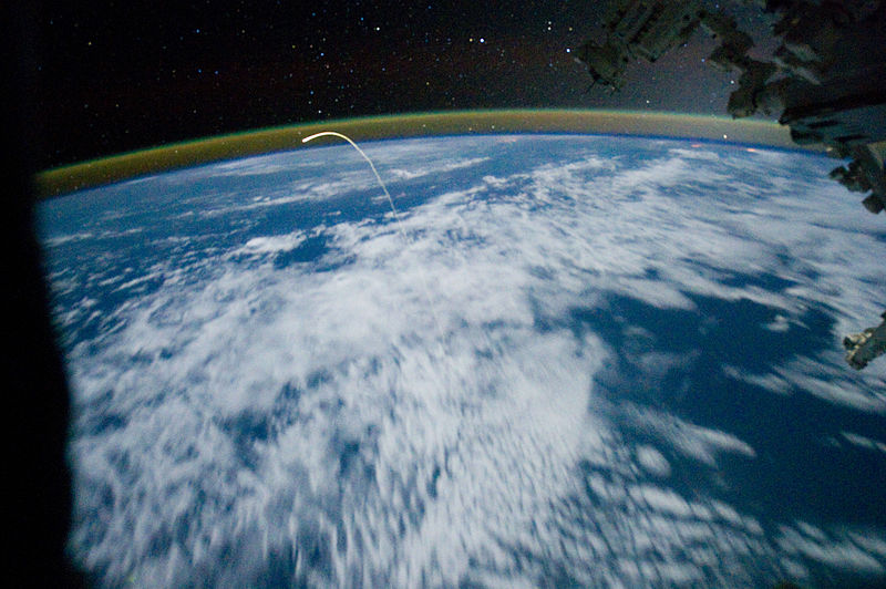国际空间站上长时间曝光拍摄的照片。照片中照亮地球的是月光。在图中划出轨迹的是亚特兰蒂斯号航天飞机。